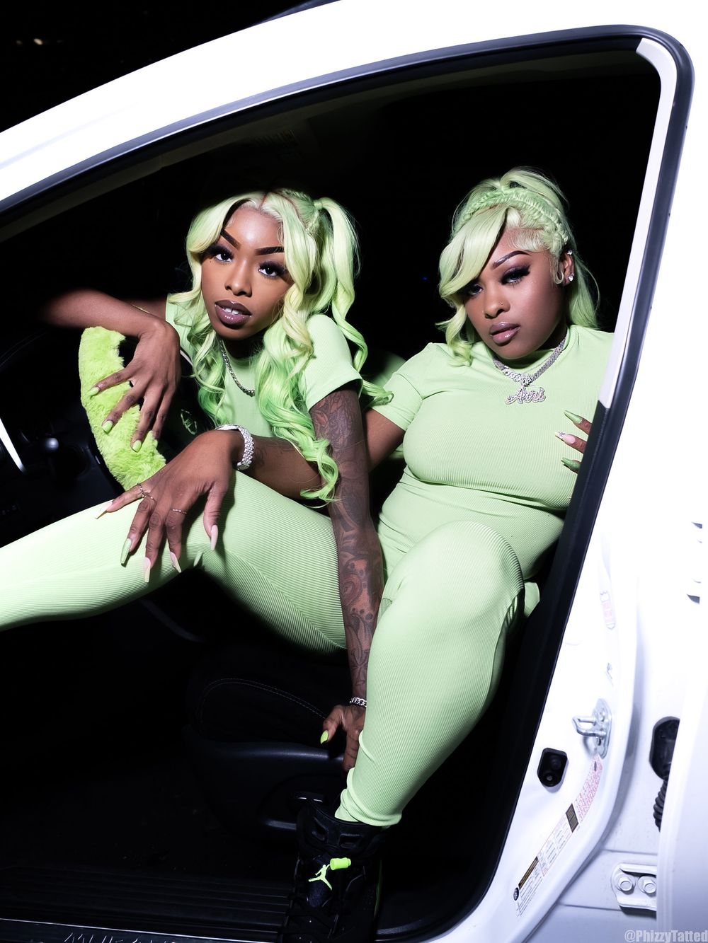 Fashion shoot featuring bright lime green outfit against white vehicle backdrop.