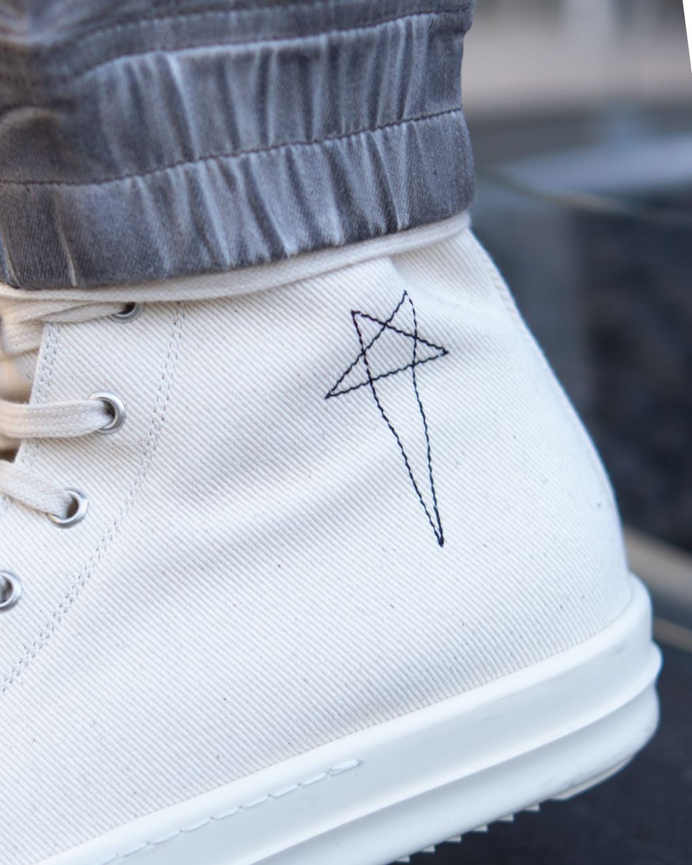 White canvas shoe with geometric star design sketched on the side.