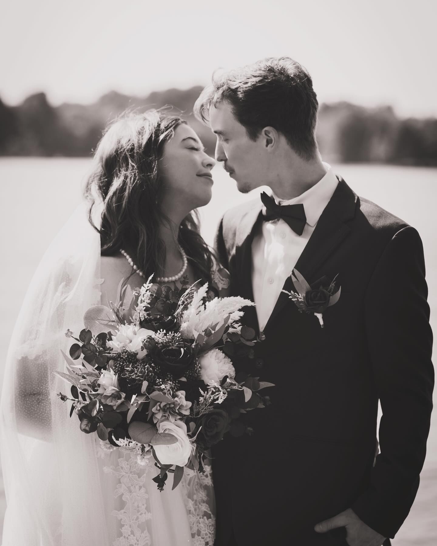 A romantic black and white wedding photo series showing tender moments between a couple in formal attire with a floral bouquet.