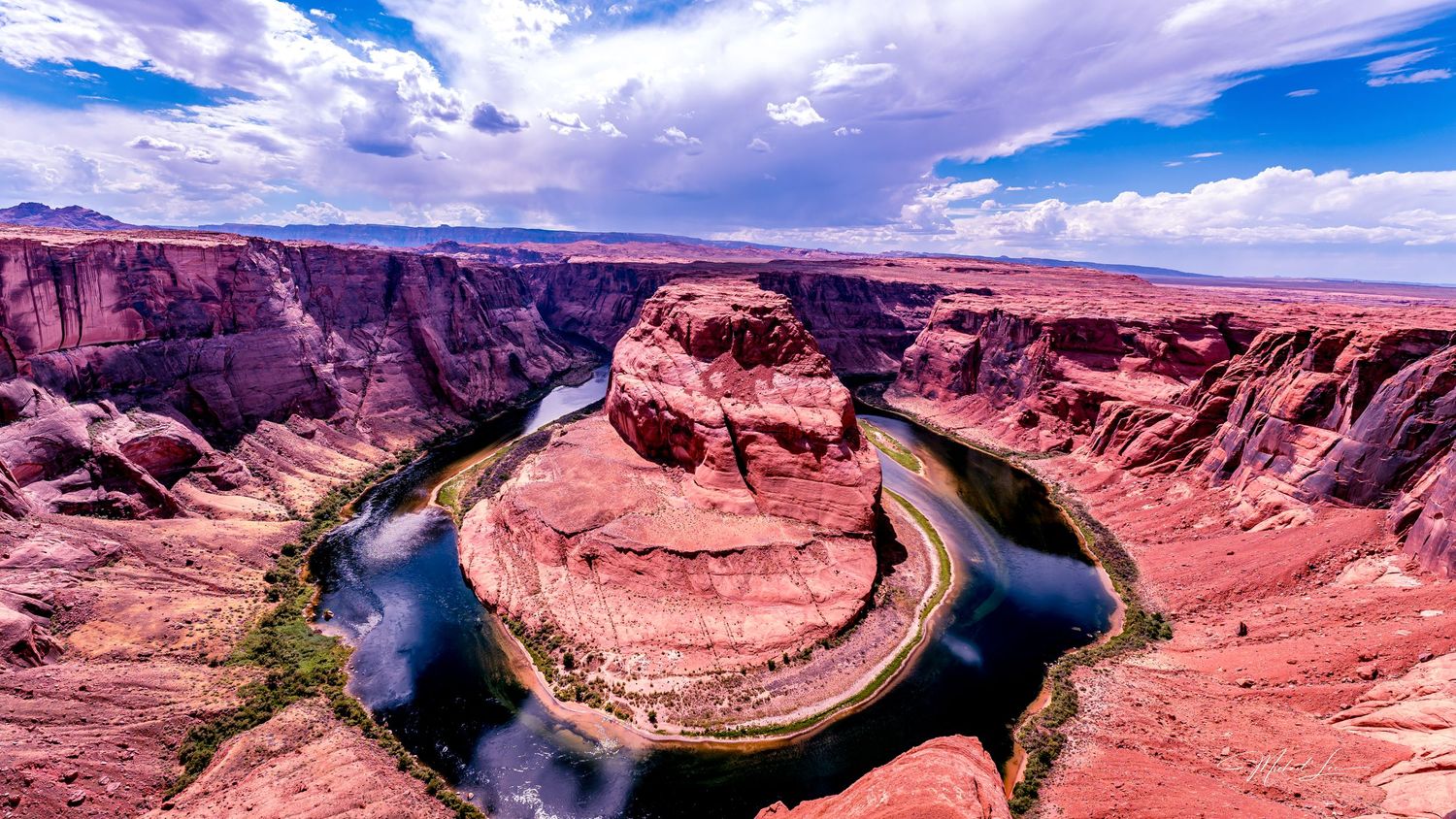 Horseshoe Bend on the Colorado River surrounded by steep red canyon walls.