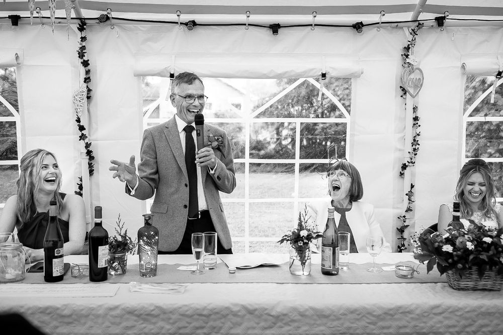 Wedding guests enjoy the farther of the bride's speech