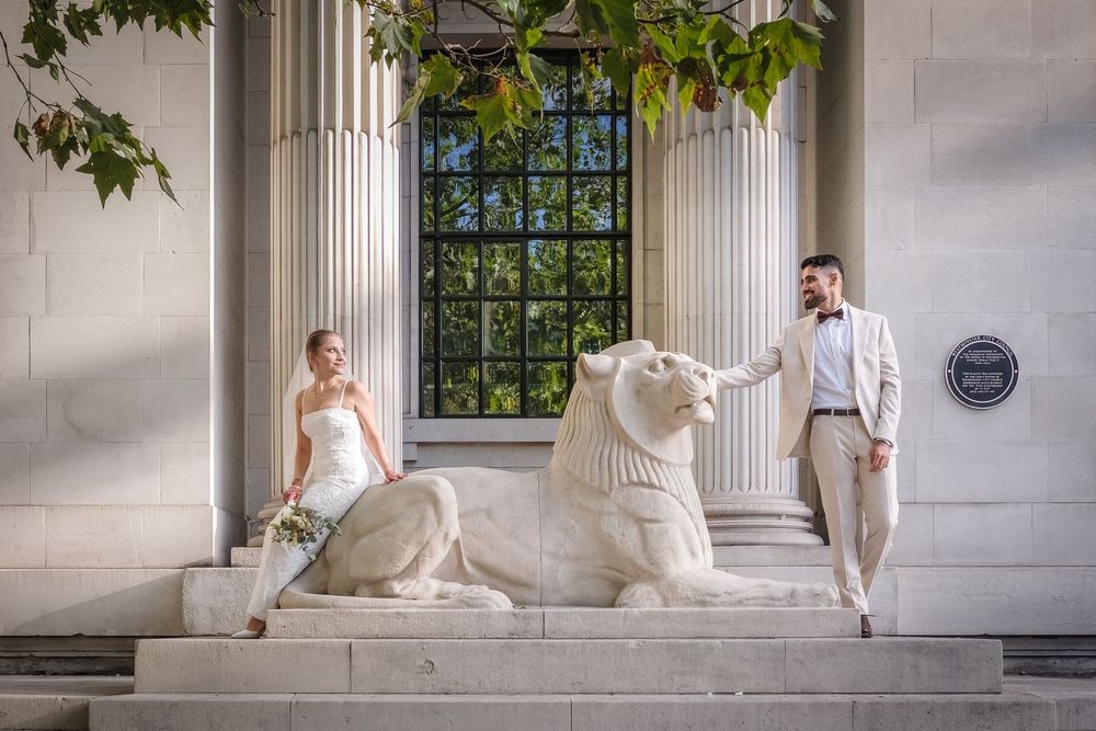A wedding couple poses in a series of elegant shots against white columns and marble architecture.