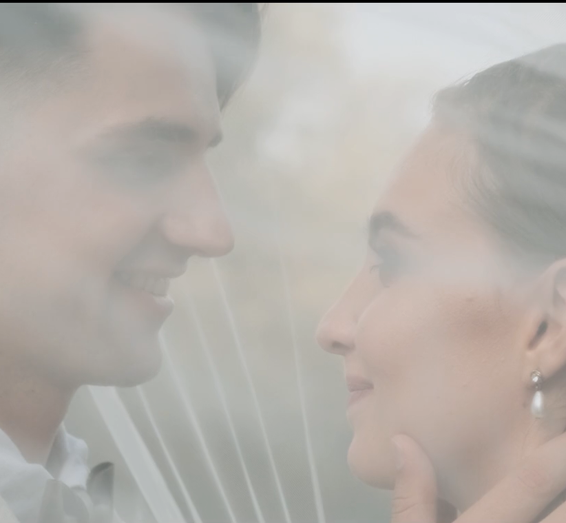 Romantic Wedding couple sharing a tender moment through a delicate veil.