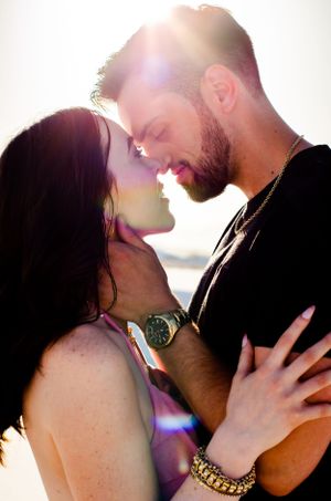 Silhouetted couples share intimate kisses against a bright backlit background in a romantic photo series. Couples photography in Las Vegas.