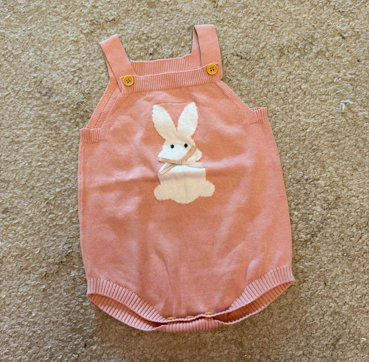 Pink baby romper with cute bunny design on front.