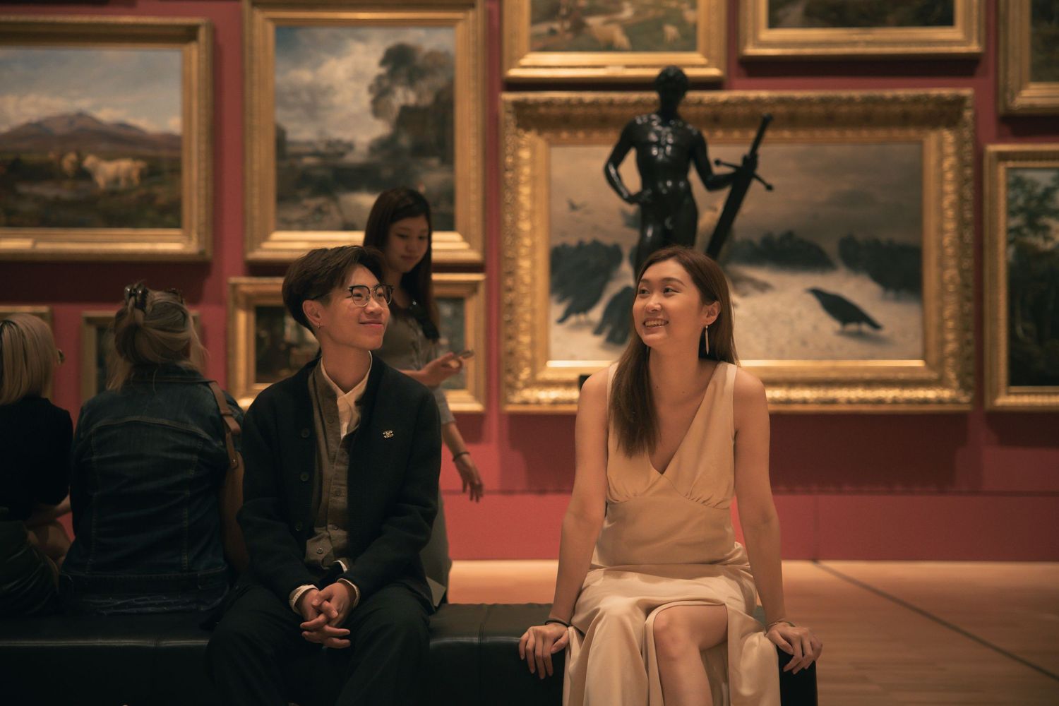 Couple sharing a moment in an art museum gallery surrounded by classic paintings.