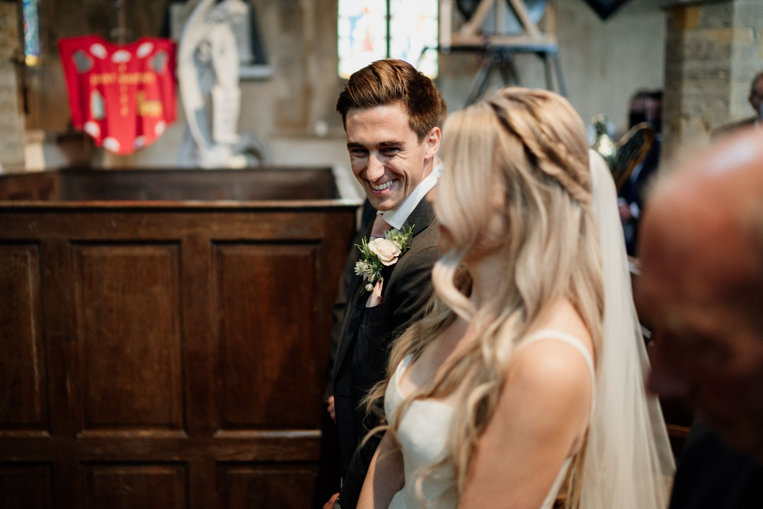 Happy couple shares a moment together during their wedding ceremony in a traditional church setting.