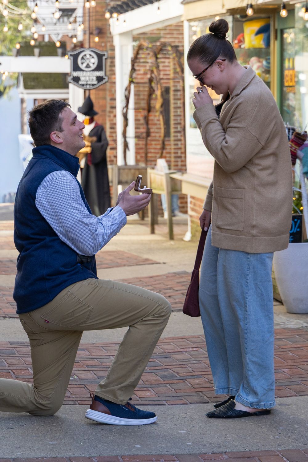 A series of photos showing someone kneeling on a brick sidewalk while proposing marriage.