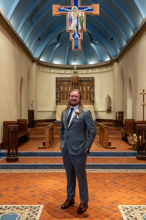 Interior of a church sanctuary with orange tiled floors and a blue domed ceiling with decorative cross.