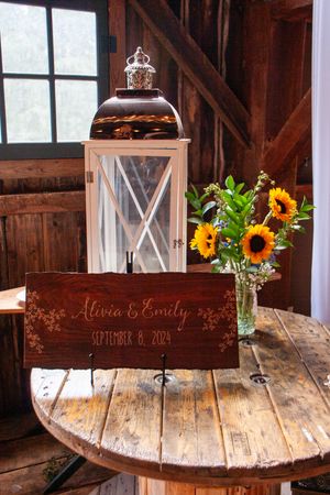 Rustic wedding decor with lantern and sunflower bouquet on wooden table.