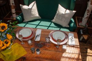 Intimate table setting with white plates and sunflower decorations in rustic venue.