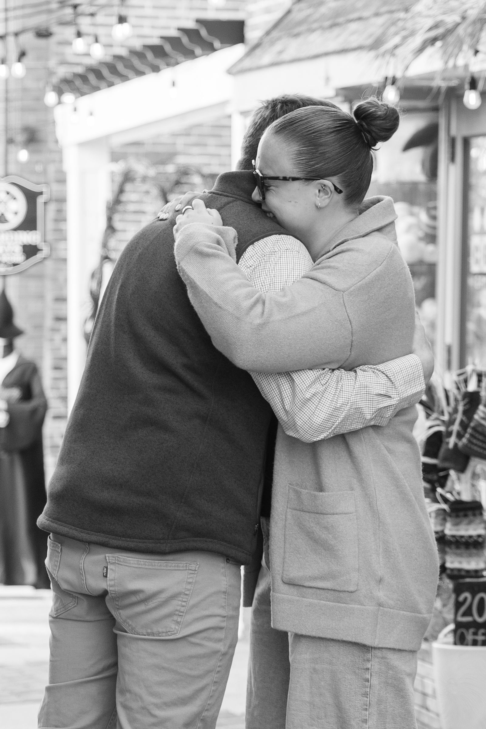 Black and white photo series showing two people embracing in matching casual outfits, captured from different angles.