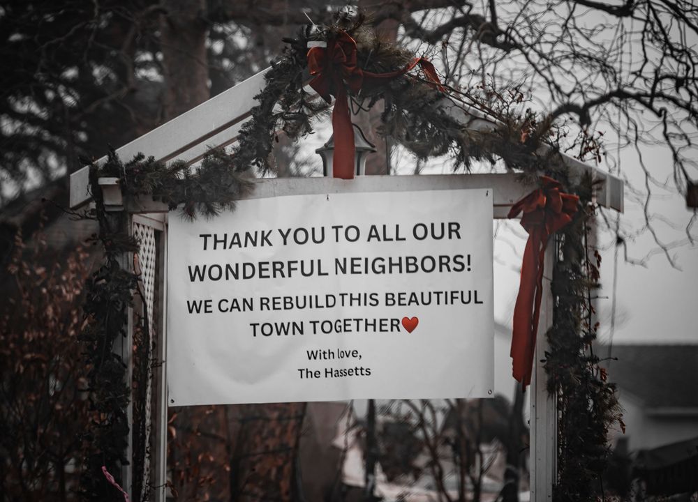 Inspirational community sign expressing gratitude to neighbors for rebuilding efforts.