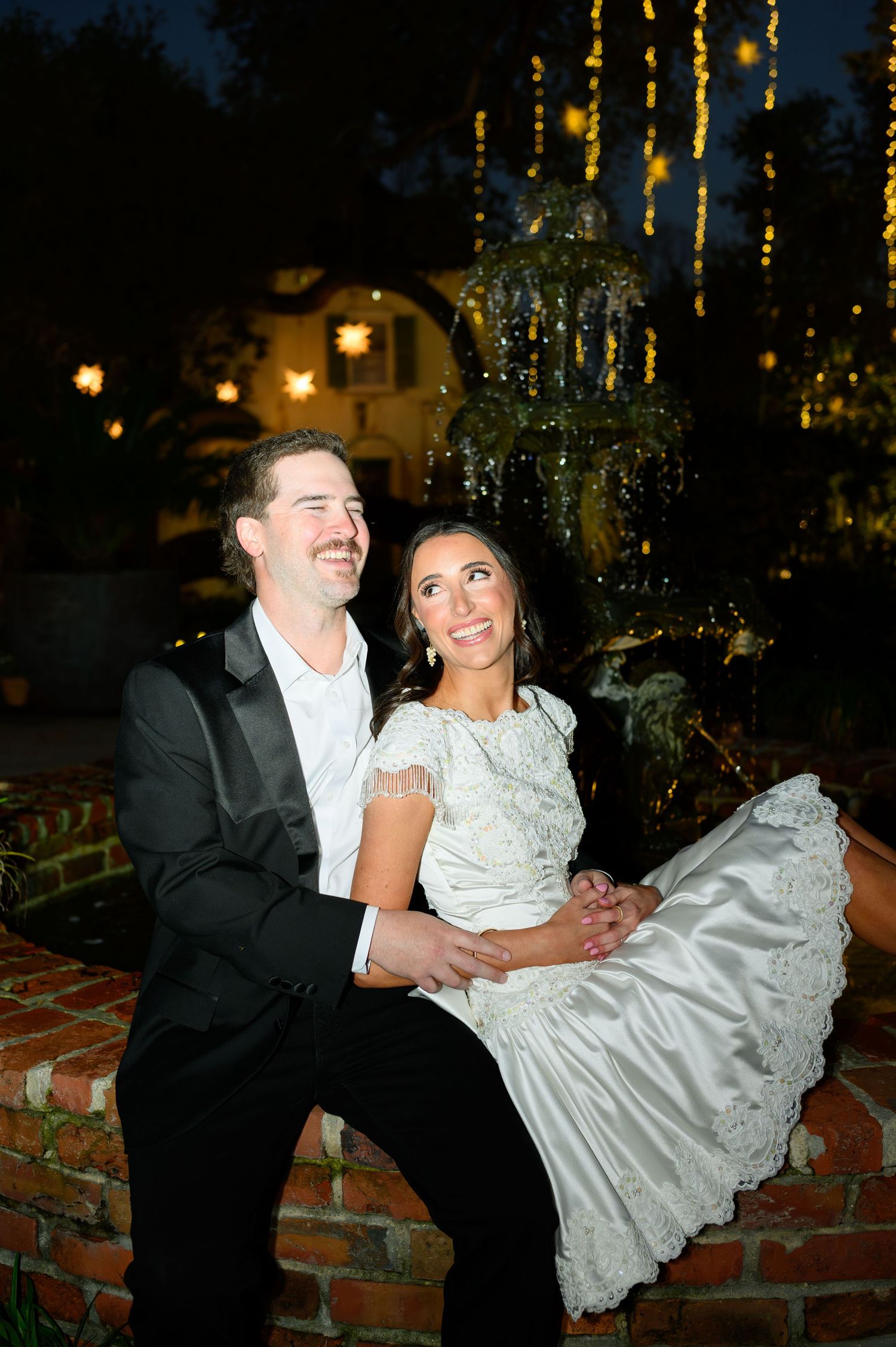 A joyful moment of genuine laughter captured during an outdoor wedding celebration.
