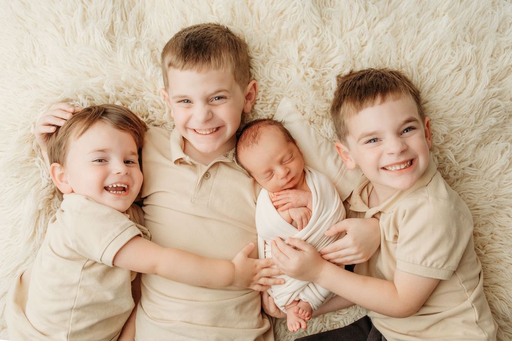 A series of sweet newborn baby photos showing sleeping infants in cream-colored outfits on white blankets.