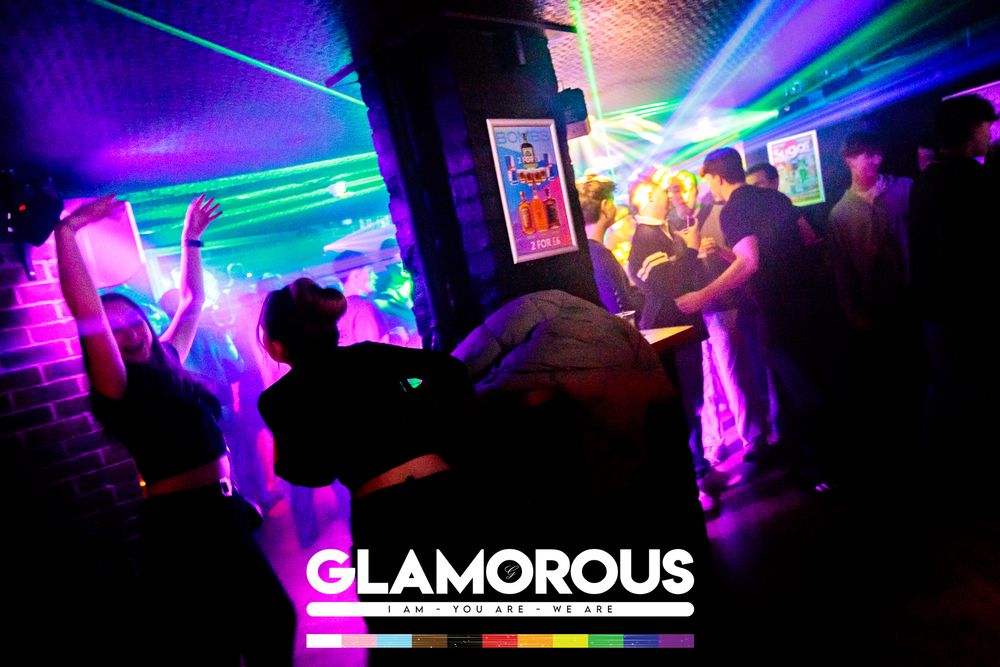 Nightclub with dramatic blue and purple laser lights creating atmospheric effects.