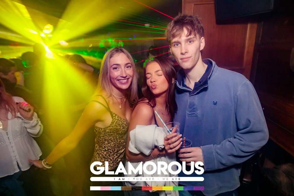 Party scene with yellow lighting effects at Glamorous nightclub.