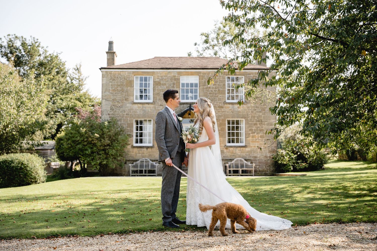 Lapstone Barn Wedding Photography Bride & Groom with their dog in front of one of the wedding venues properties