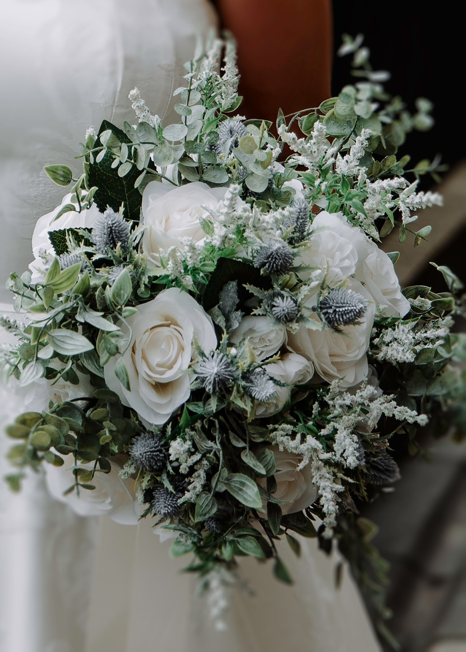 Elegant white and green wedding bouquet with roses, eucalyptus and delicate florals.