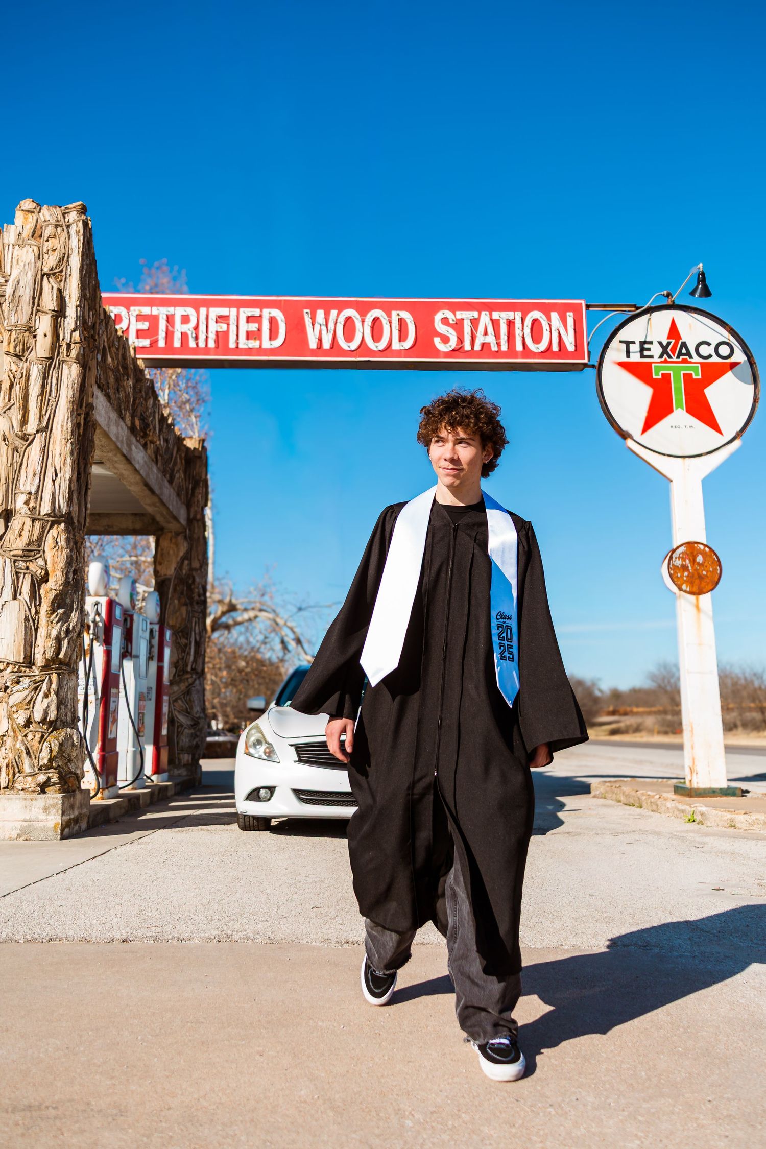A series of fashion photos showing a person in a black coat posing at a vintage gas station in a desert setting. senior session dallas