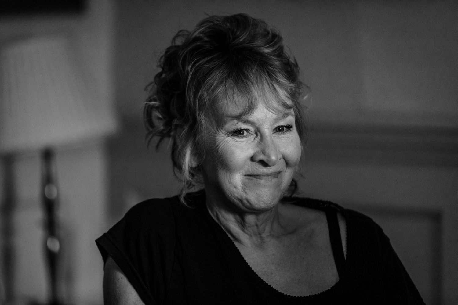 A series of black and white portrait photos showing a woman's expressions ranging from pensive to joyful.