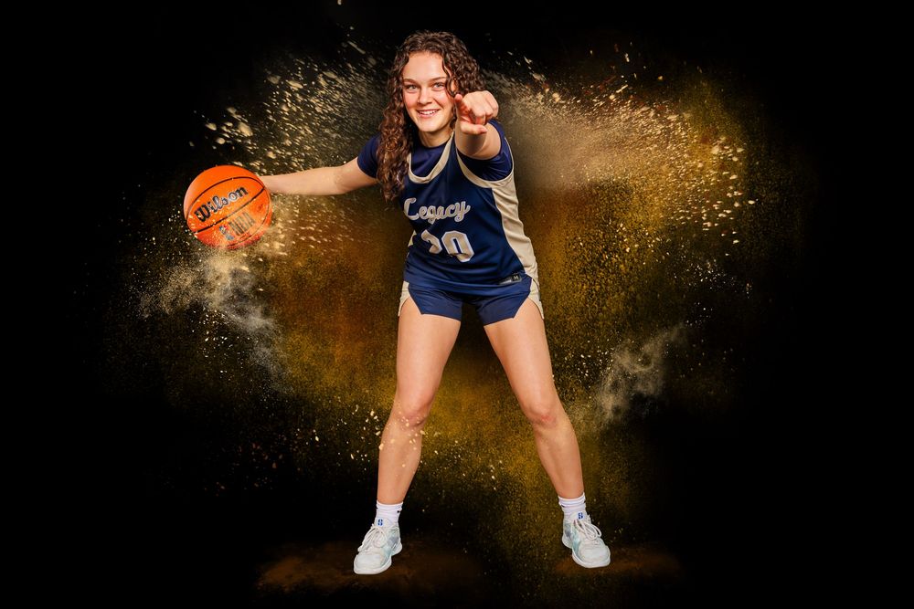 Athletes in navy blue uniforms pose against dark background with dramatic gold powder effects.