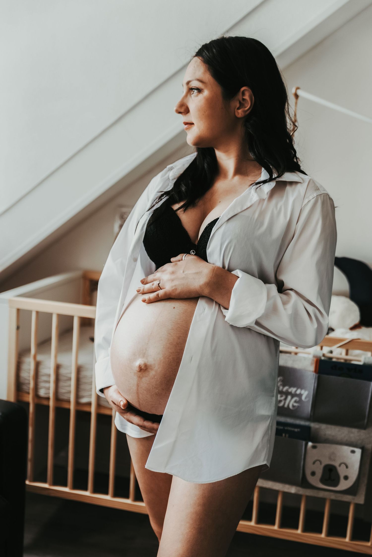 Artistic maternity photo featuring side profile and white button-down shirt.