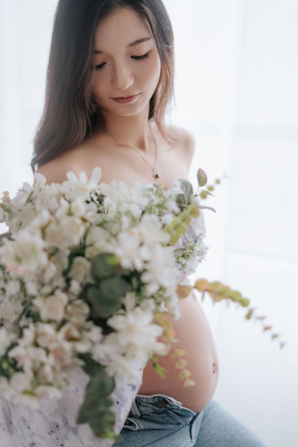 Delicate bridal portraits featuring soft white floral bouquets and off-shoulder styling in a bright natural setting.