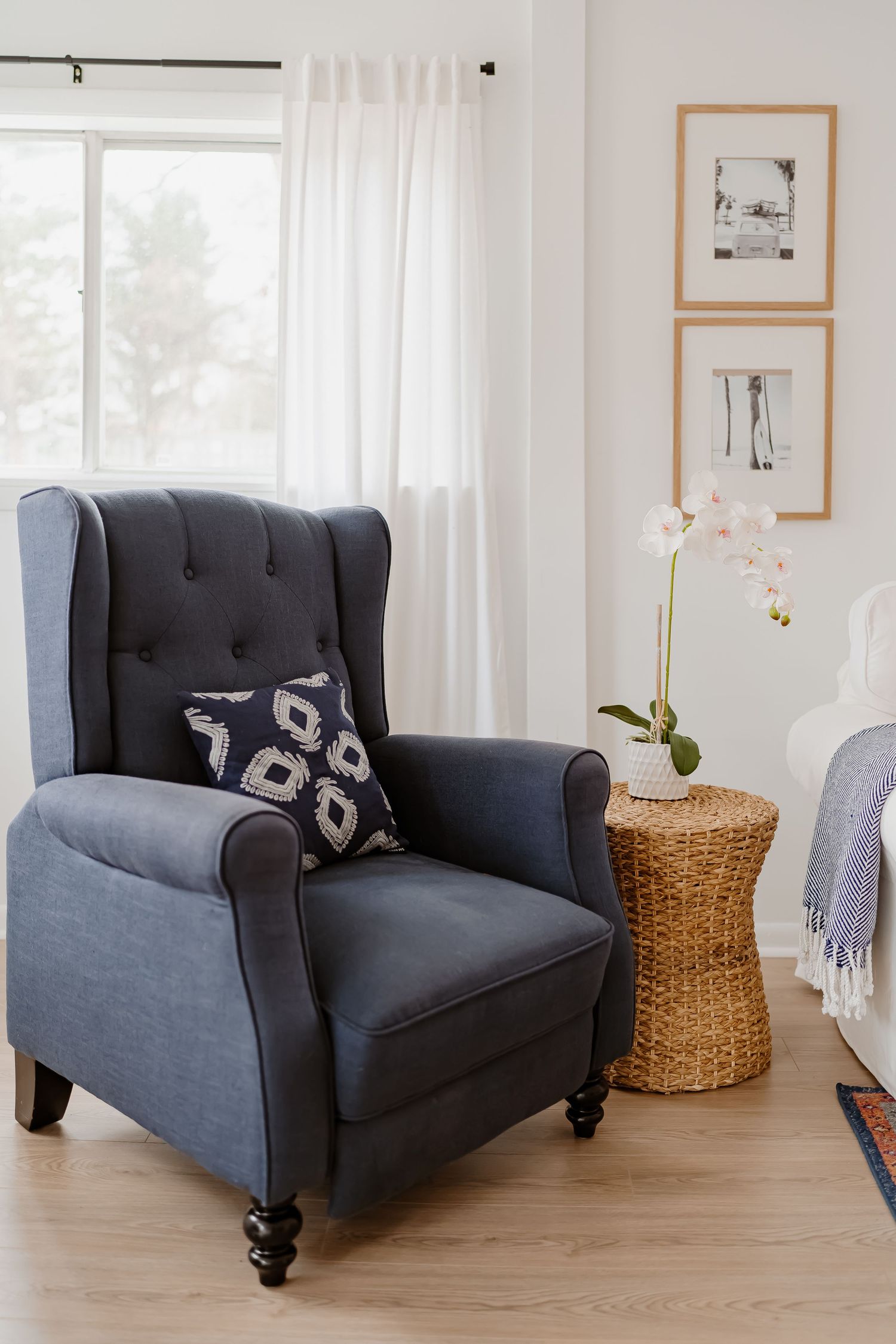 A bright and airy bedroom features white walls, natural light, and minimalist decor with soft gray accents.