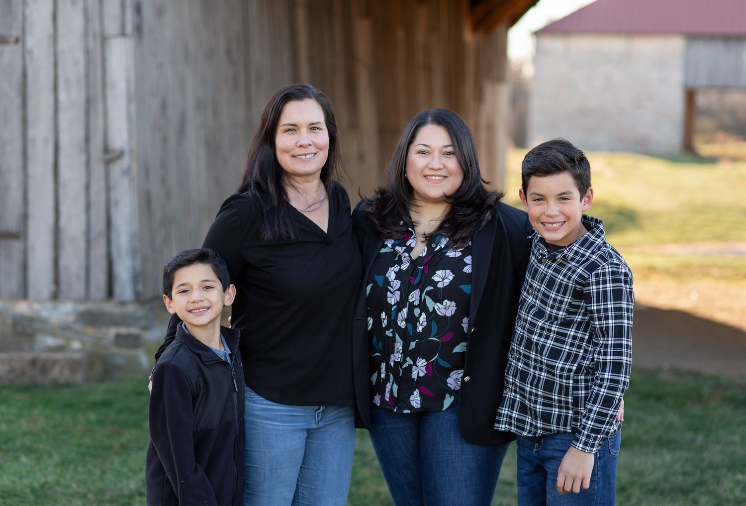 A family poses together outdoors in coordinating black and blue outfits for a portrait session.