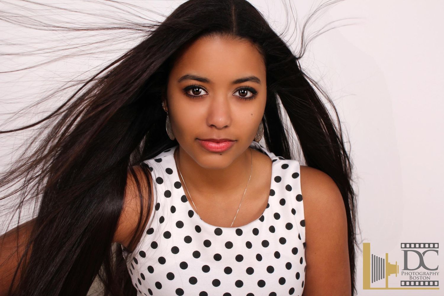 A series of close-up photos showing someone wearing a white and black polka dot top with pink lipstick.