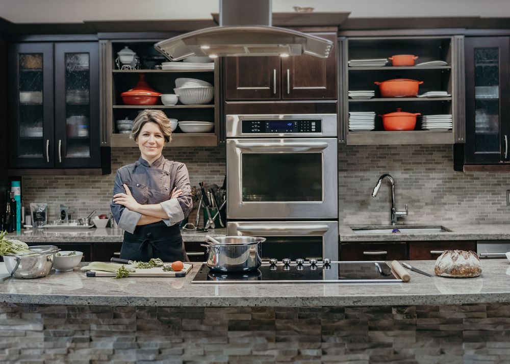 Modern kitchen with stone countertop showing food preparation and cooking activities in a time-lapse sequence.