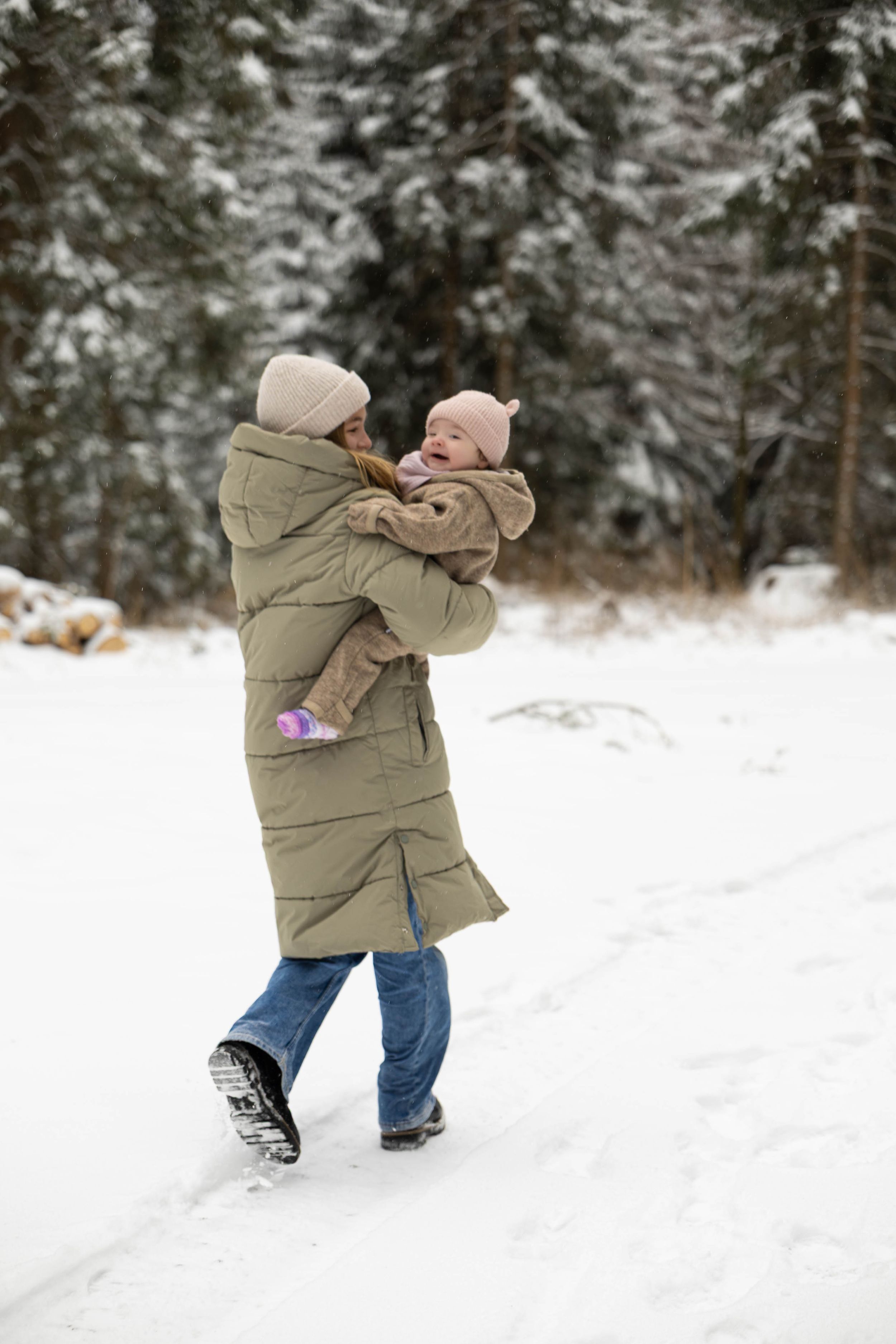 A sequence of photos shows someone in a beige winter coat throwing snow in the air while playing in a snowy forest.