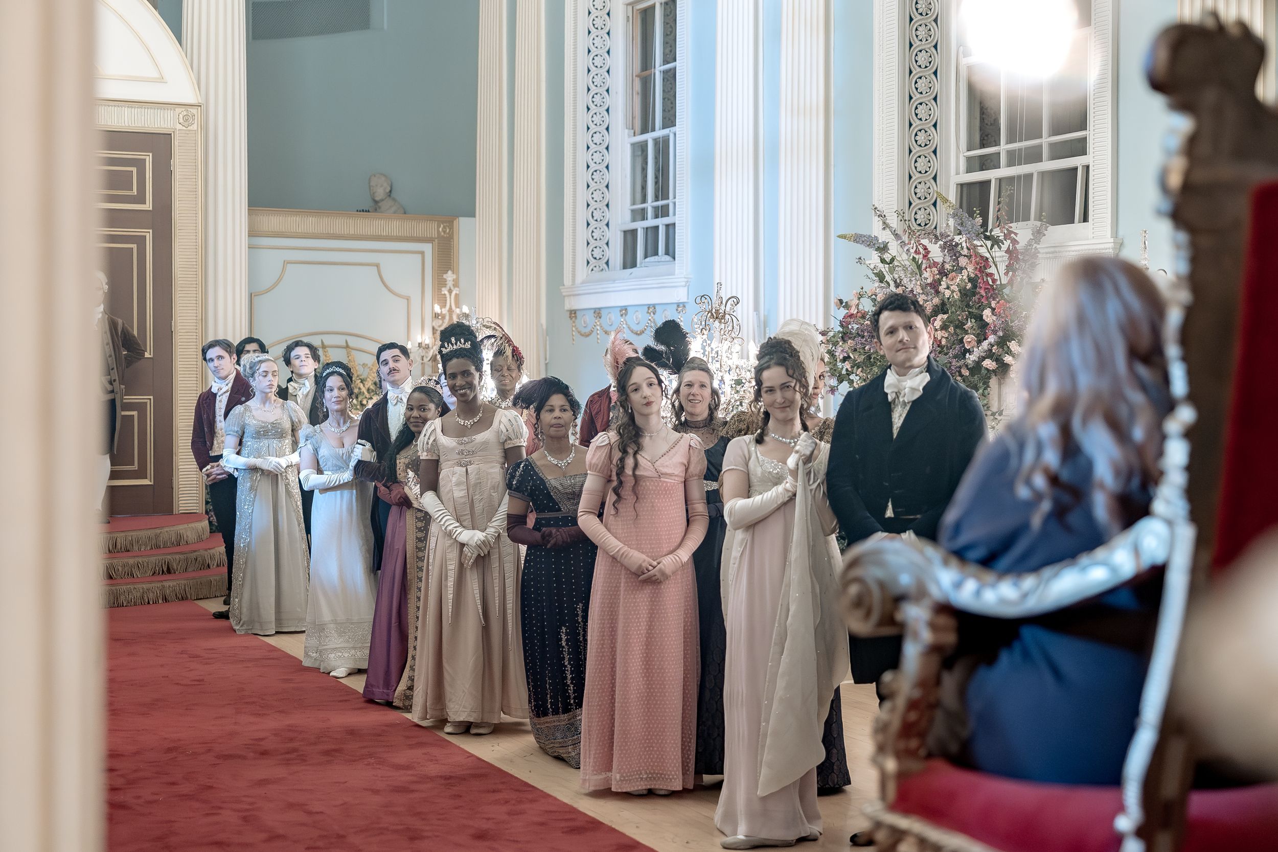 Bridgerton at Newark Town Hall in Nottinghamshire, photographed behind the scenes for the Netflix production. ballroom guests look on.