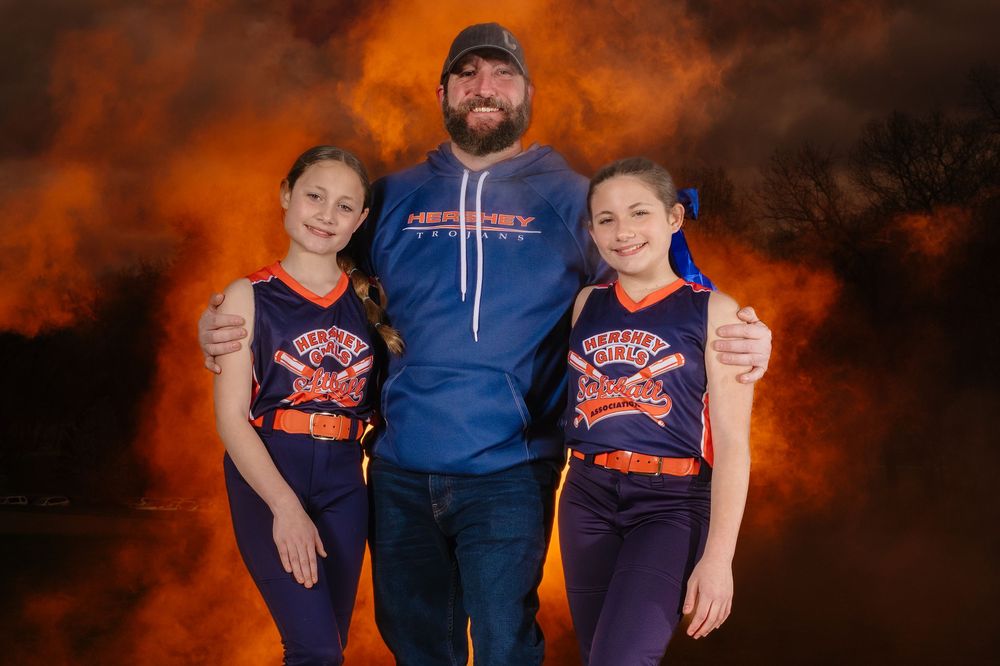 Recreational softball players and coach with dramatic lighting in Hershey PA, photographed by SportsFox Photography.