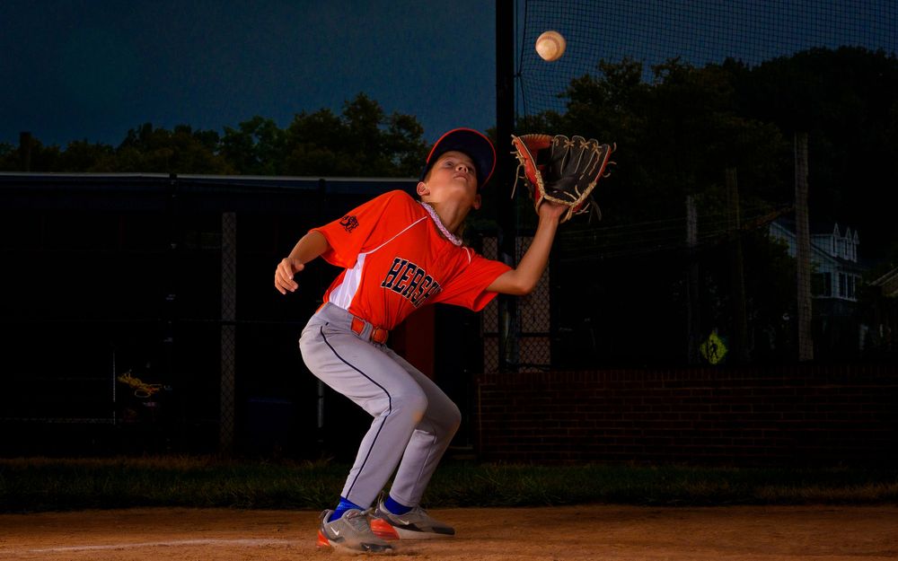 Little League All-Star baseball player at home plate with dramatic lighting in Hershey PA, photographed by SportsFox Photography.
