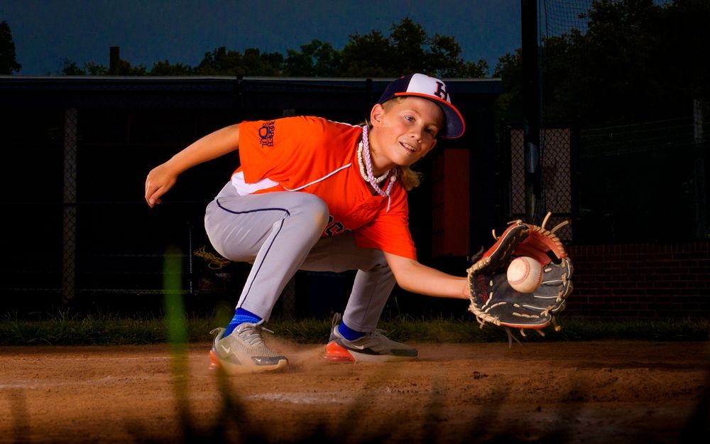 Little League All-Star baseball player at home plate with dramatic lighting in Hershey PA, photographed by SportsFox Photography.