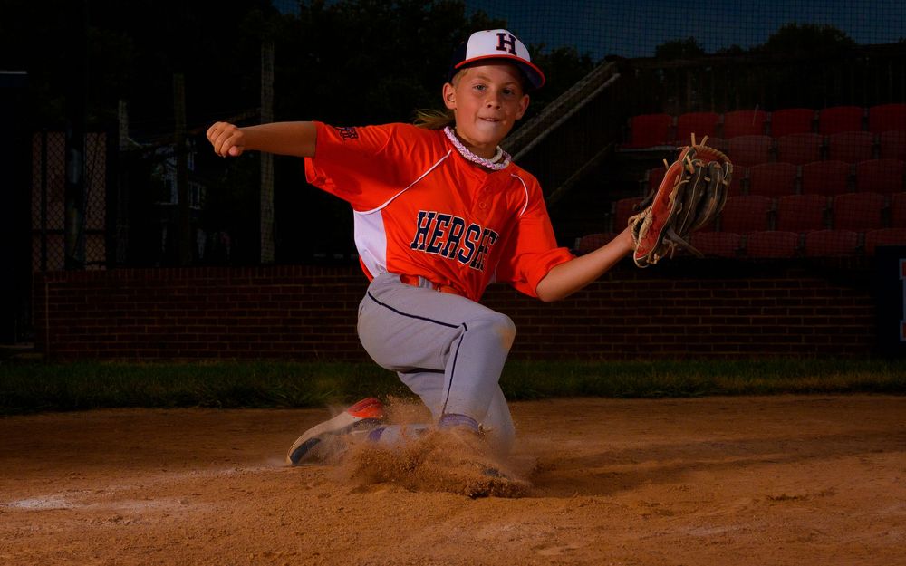 Little League All-Star baseball player at home plate with dramatic lighting in Hershey PA, photographed by SportsFox Photography.