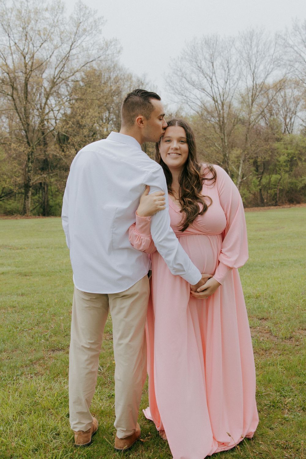 A tender outdoor portrait of a couple embracing in coordinated outfits.