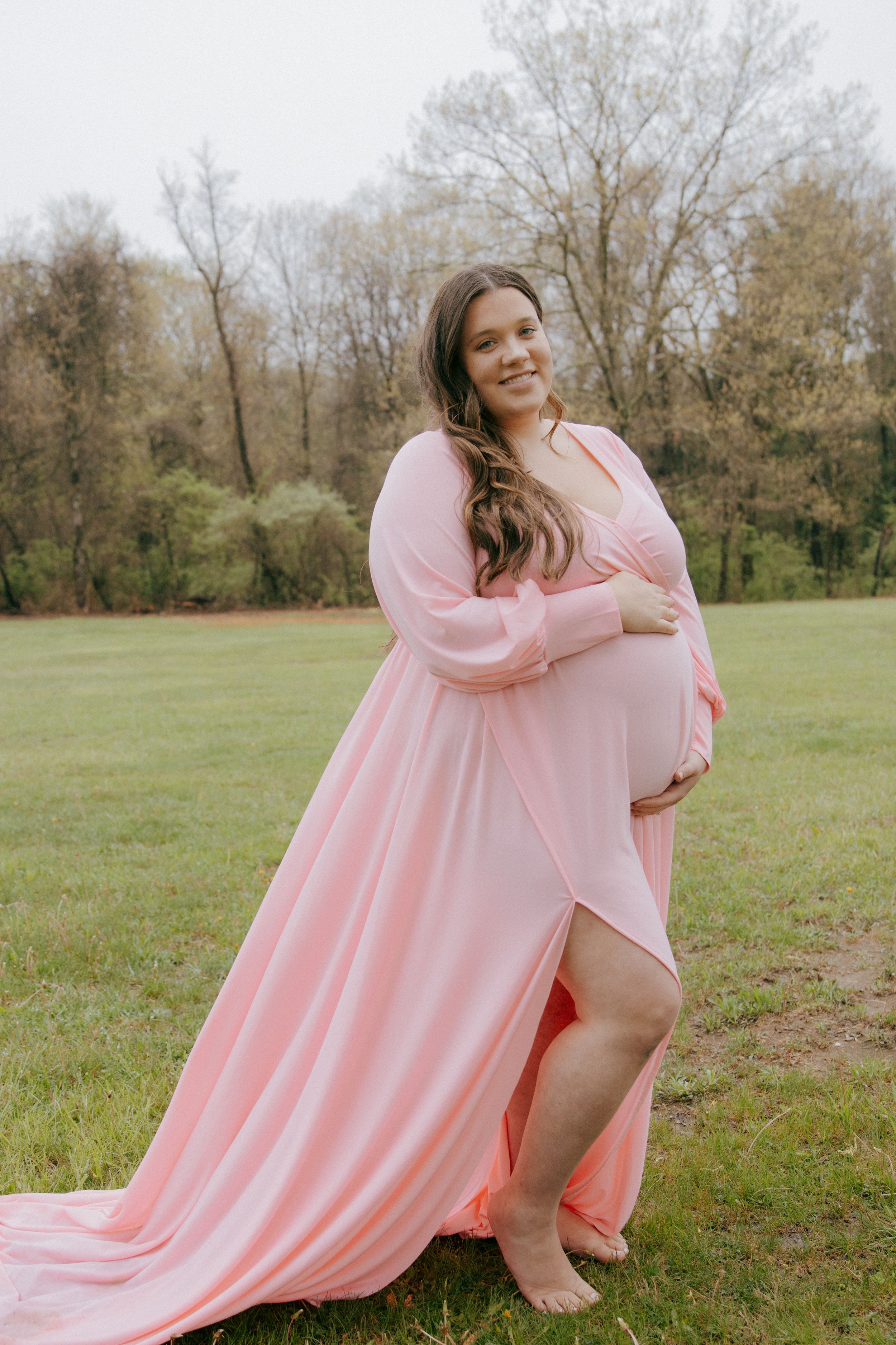 A flowing pink dress creates elegant movement against a natural outdoor backdrop.