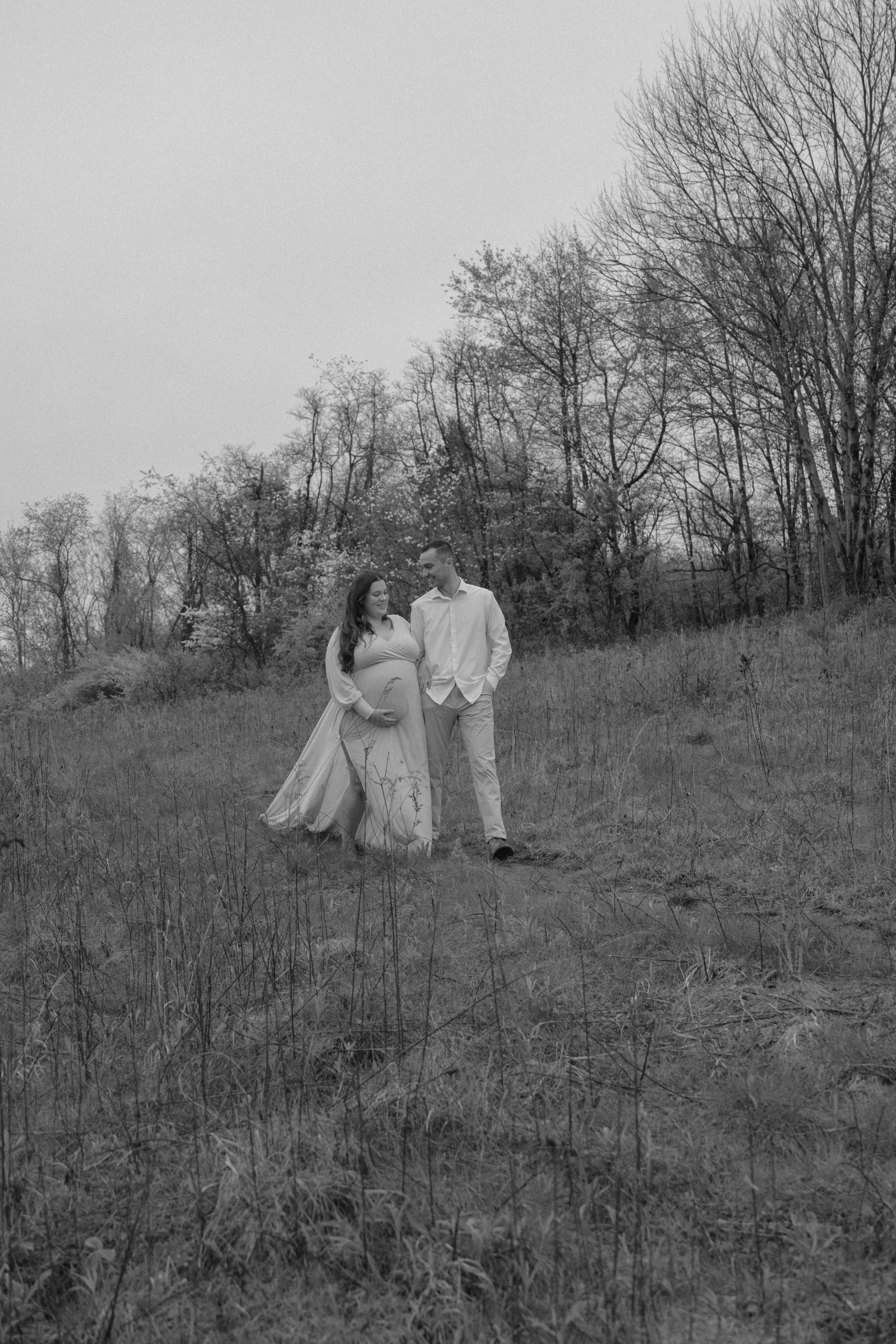 Black and white photos capture a couple's tender moments on a scenic hillside.