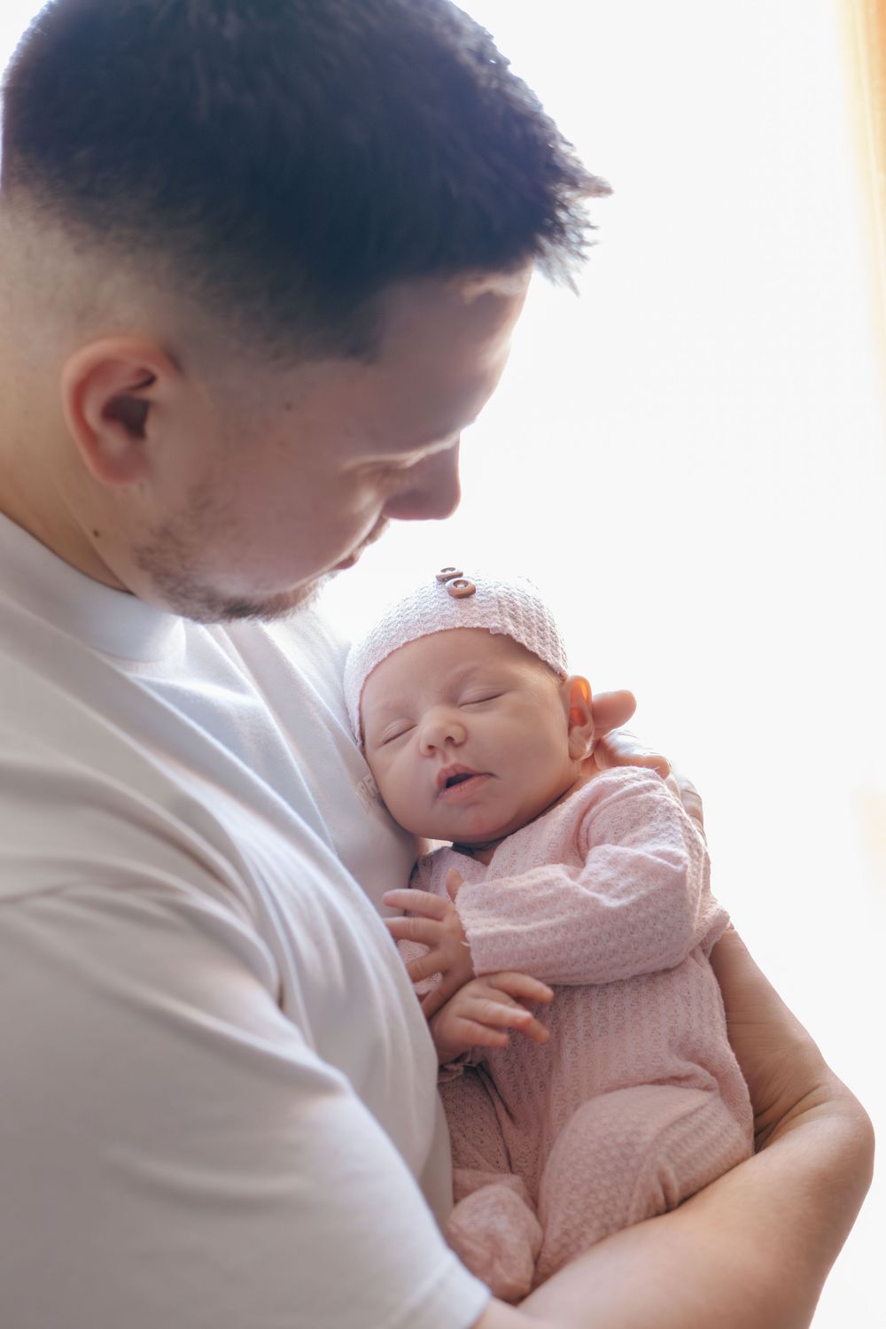 Close-up view of a peaceful newborn baby being cradled in loving arms.