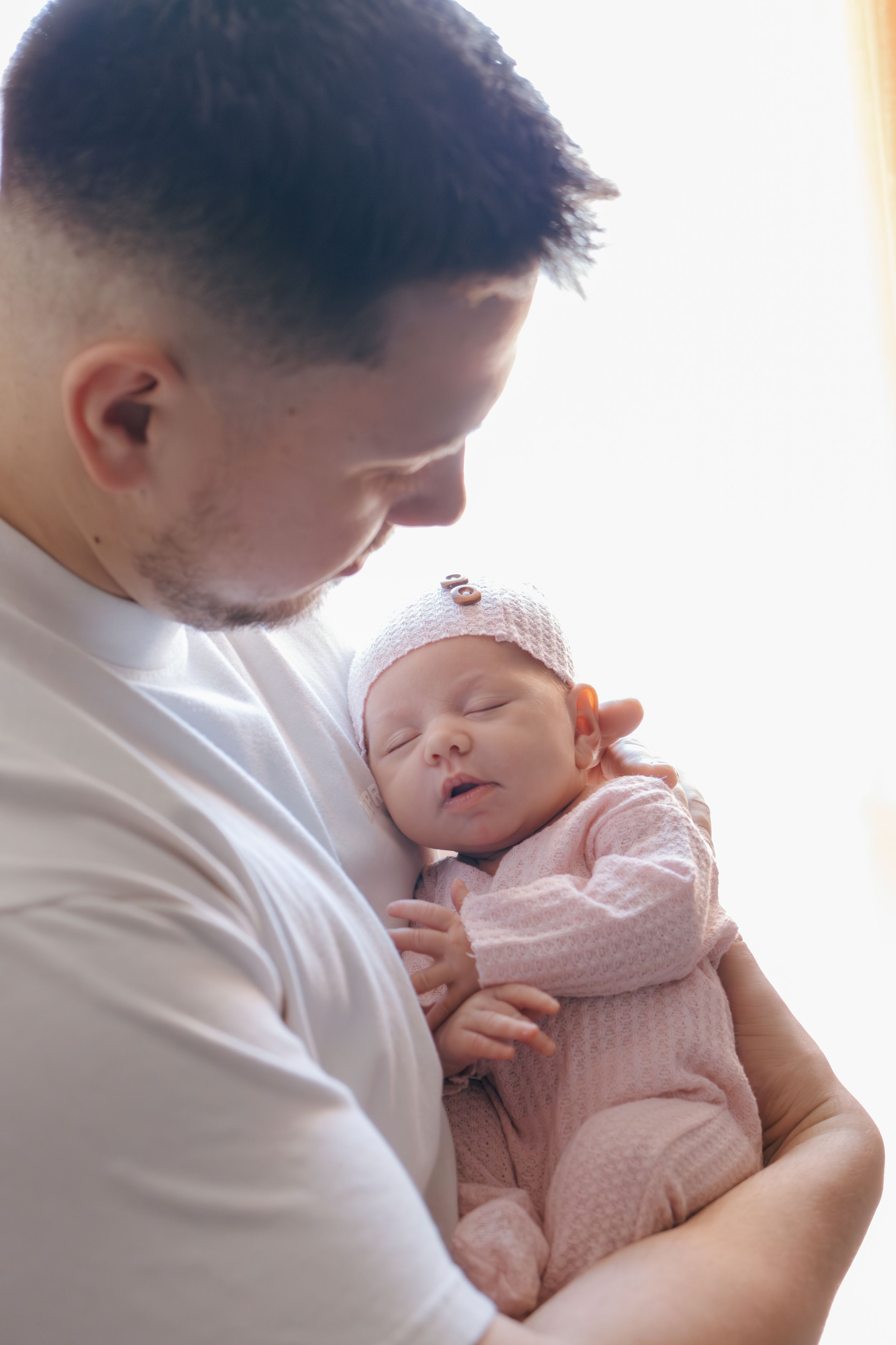 Close-up view of a peaceful newborn baby being cradled in loving arms.