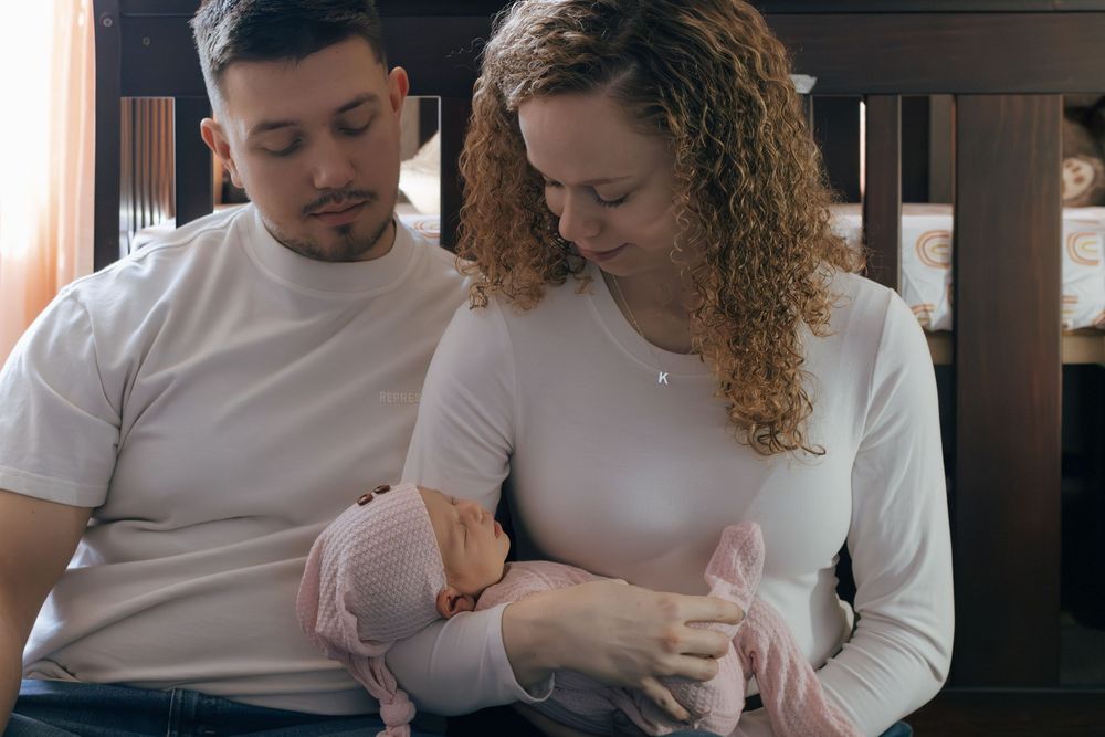 Intimate indoor portrait of couple in matching white tops.