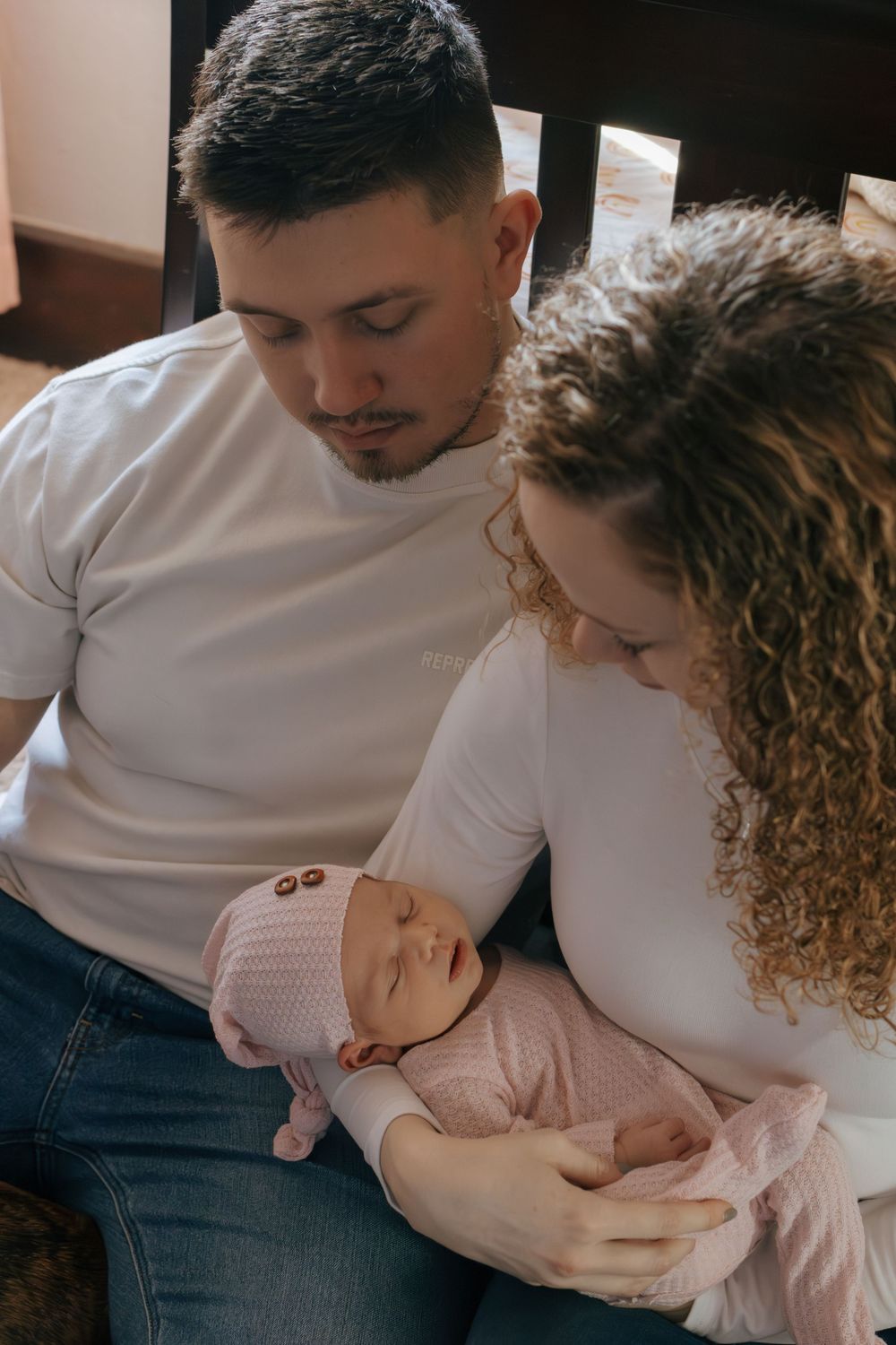 Couple shares tender moment while sitting together in nursery room.