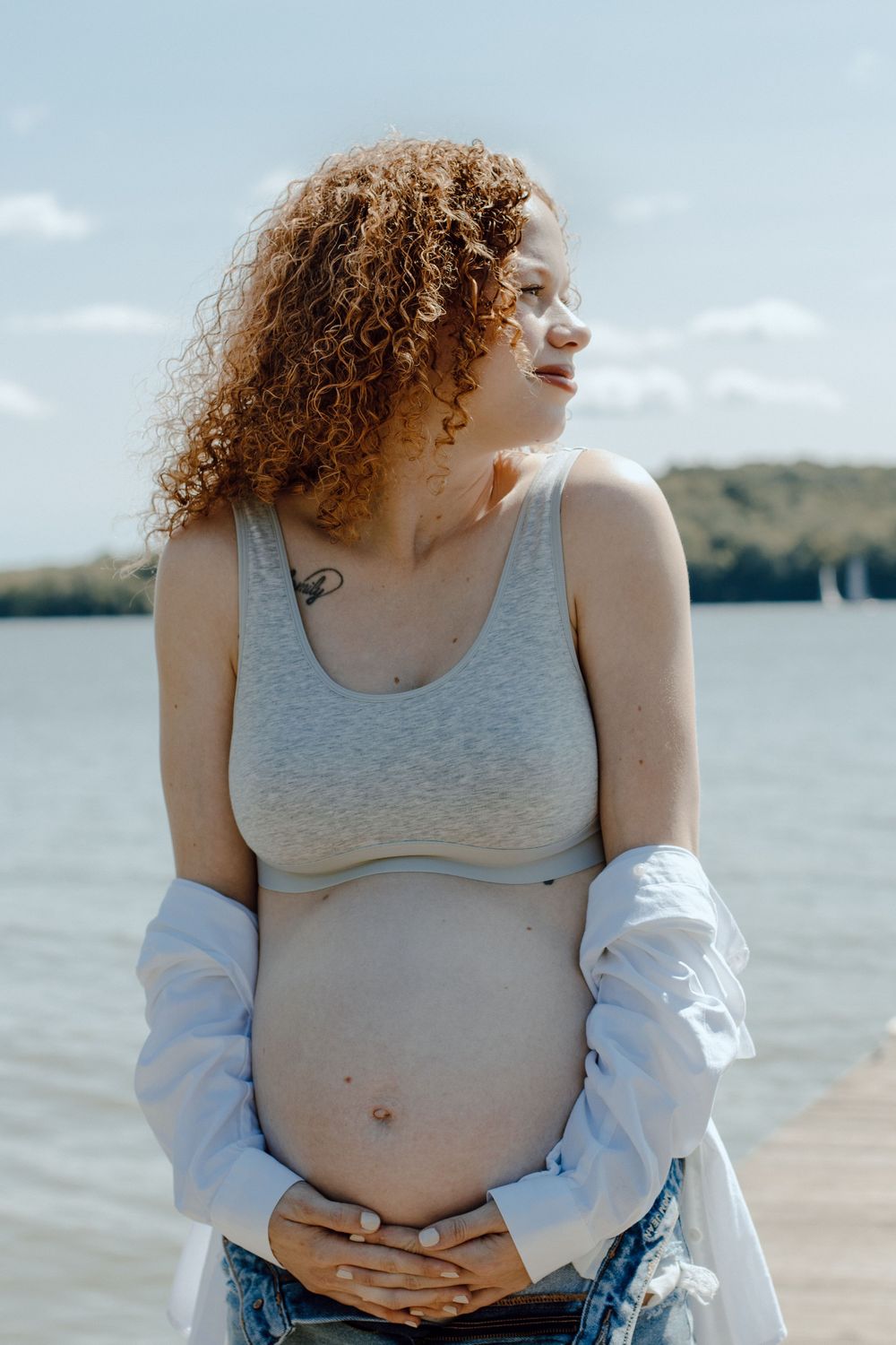 Waterfront maternity session showing gentle moments and natural expressions.