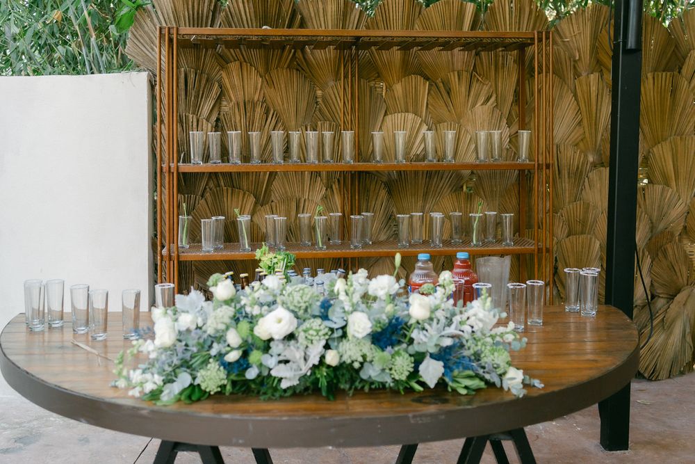 A rustic wedding venue decorated with elegant floral arrangements and wooden accents features a circular arch setup.