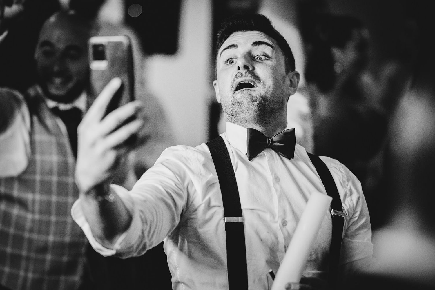 Invitado con tirantes y pajarita haciéndose un selfie mientras baila en la fiesta de una boda en Asturias