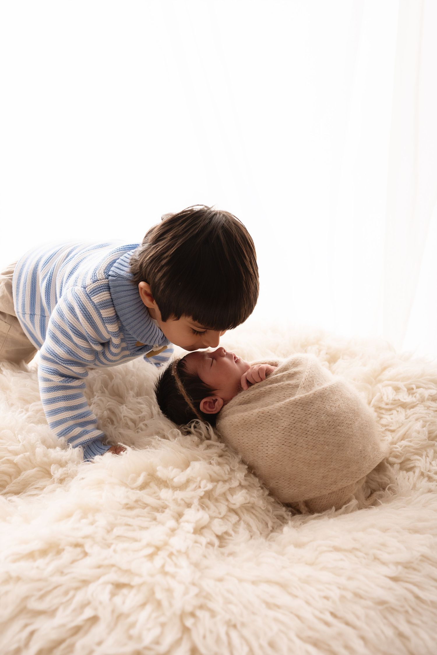 A person lies face down on a plush cream-colored shag carpet in a cozy indoor setting.
