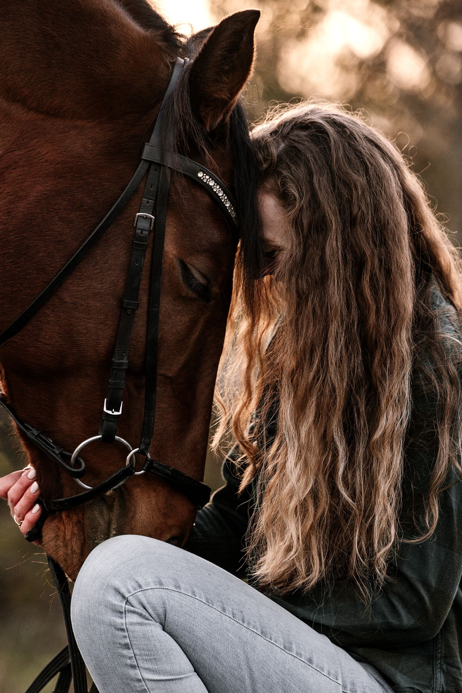 Kvinde og hest fotograferet tæt sammen.